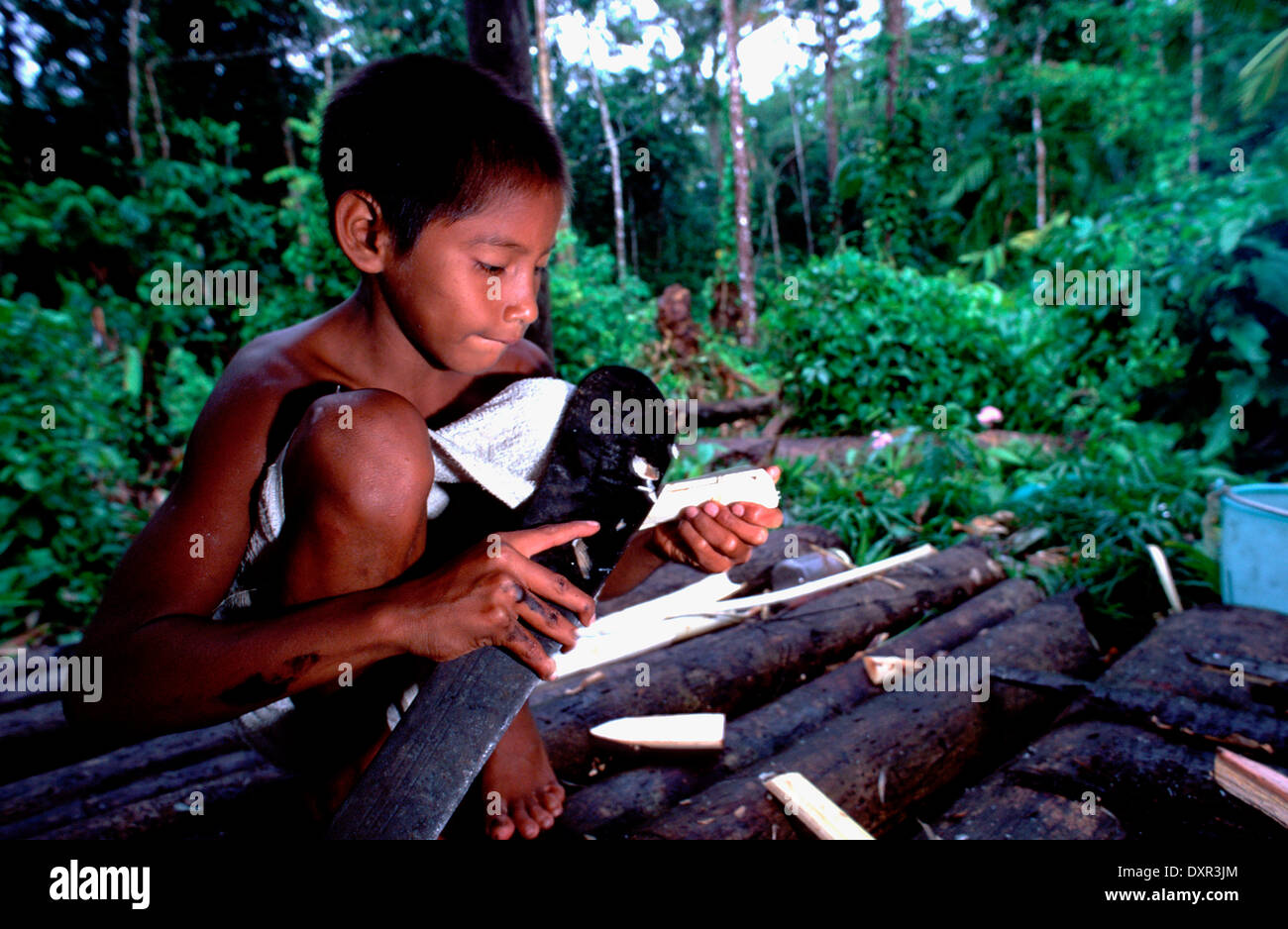 A child with a knife in the Orinoco River. The Warao are an indigenous people inhabiting northeastern Venezuela and western Stock Photo