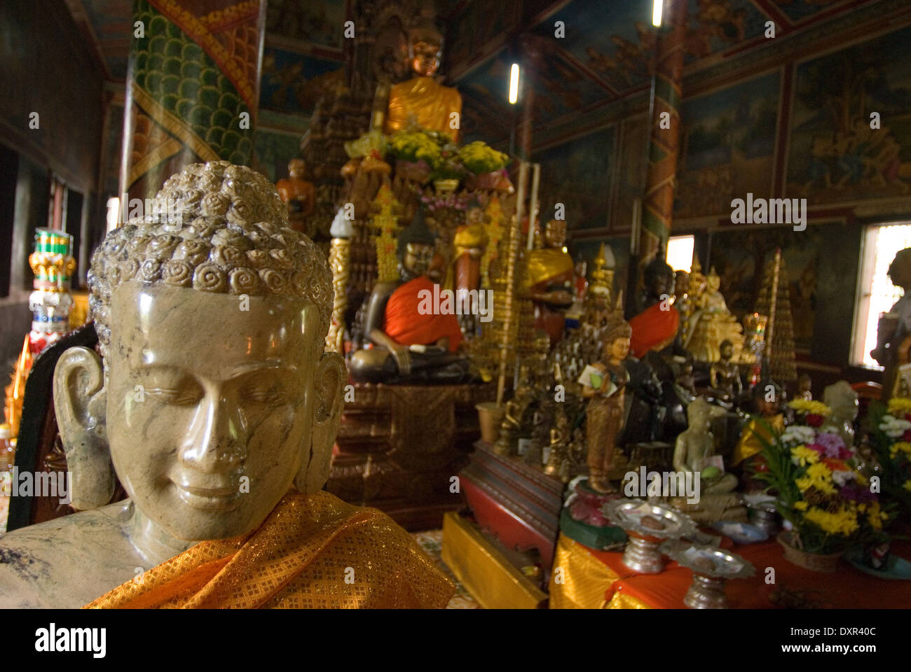 Inside Wat Phnom, Phnom Penh, Cambodia. Candles and Buddha statue in Wat Phnom, Phnom Penh, Cambodia. Wat Phnom is a Buddhist Stock Photo