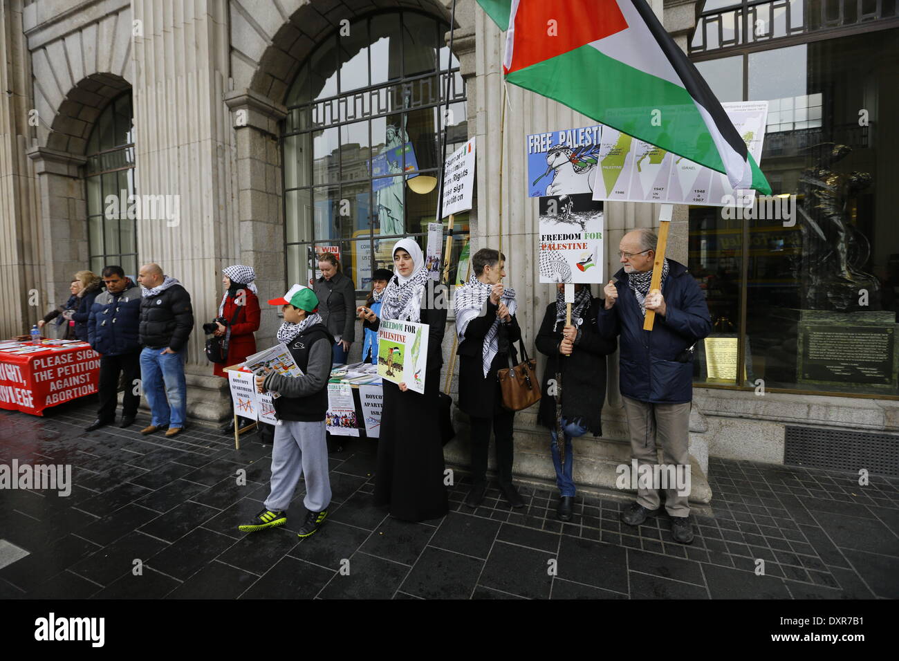 Dublin, Ireland. 29th March 2014. Activists from the Ireland Palestine Solidarity Campaign stand outside the GPO (General Post Office), holding Palestinian flags and posters. The Ireland Palestine Solidarity Campaign (IPSC) protested in Dublin's O'Connell Street on the 38th anniversary of the 1976 land day protest against discrimination of Palestinians by Israel and the expansion of Israeli settlements in Palestinian territory. Credit:  Michael Debets/Alamy Live News Stock Photo