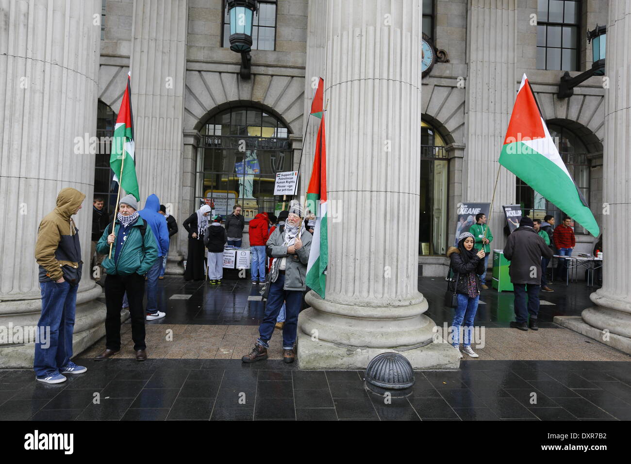 Dublin, Ireland. 29th March 2014. Activists from the Ireland Palestine Solidarity Campaign stand outside the GPO (General Post Office), holding Palestinian flags and posters. The Ireland Palestine Solidarity Campaign (IPSC) protested in Dublin's O'Connell Street on the 38th anniversary of the 1976 land day protest against discrimination of Palestinians by Israel and the expansion of Israeli settlements in Palestinian territory. Credit:  Michael Debets/Alamy Live News Stock Photo