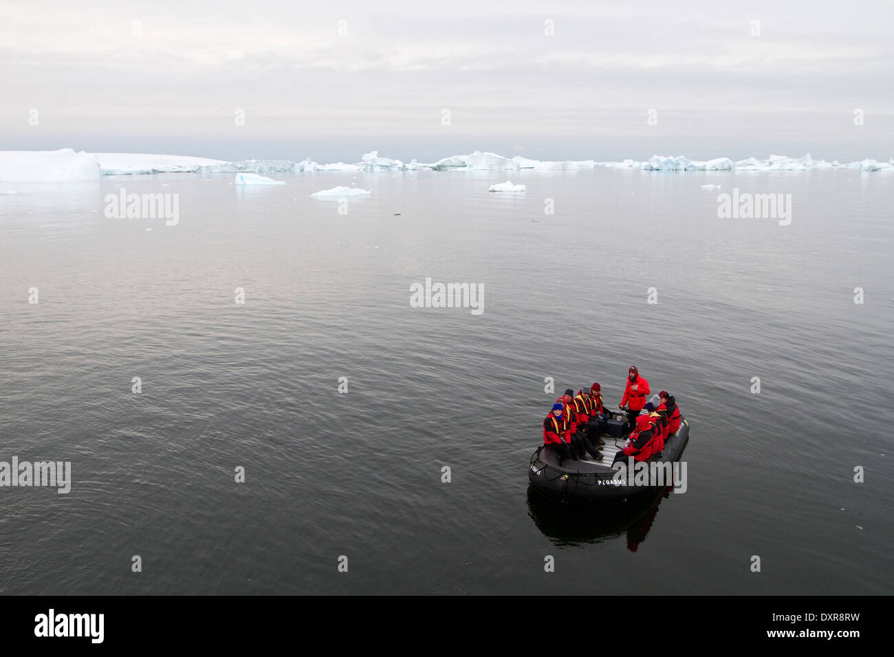 Antarctica cruise ship tourism among the landscape of Antarctic iceberg, icebergs, glacier, and ice with tourists in zodiac. Stock Photo