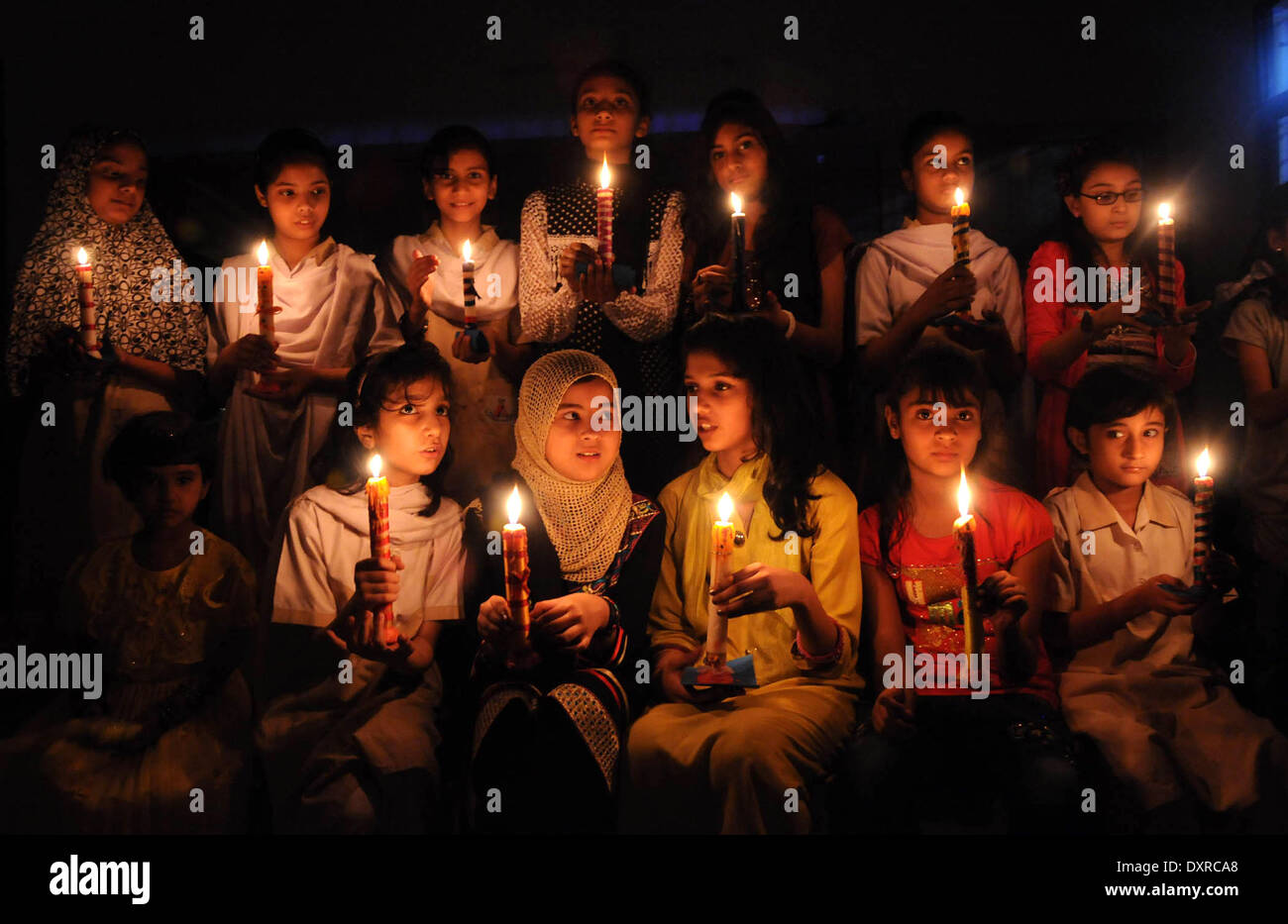 Karachi. 29th Mar, 2014. Pakistani girls hold candles during a ceremony