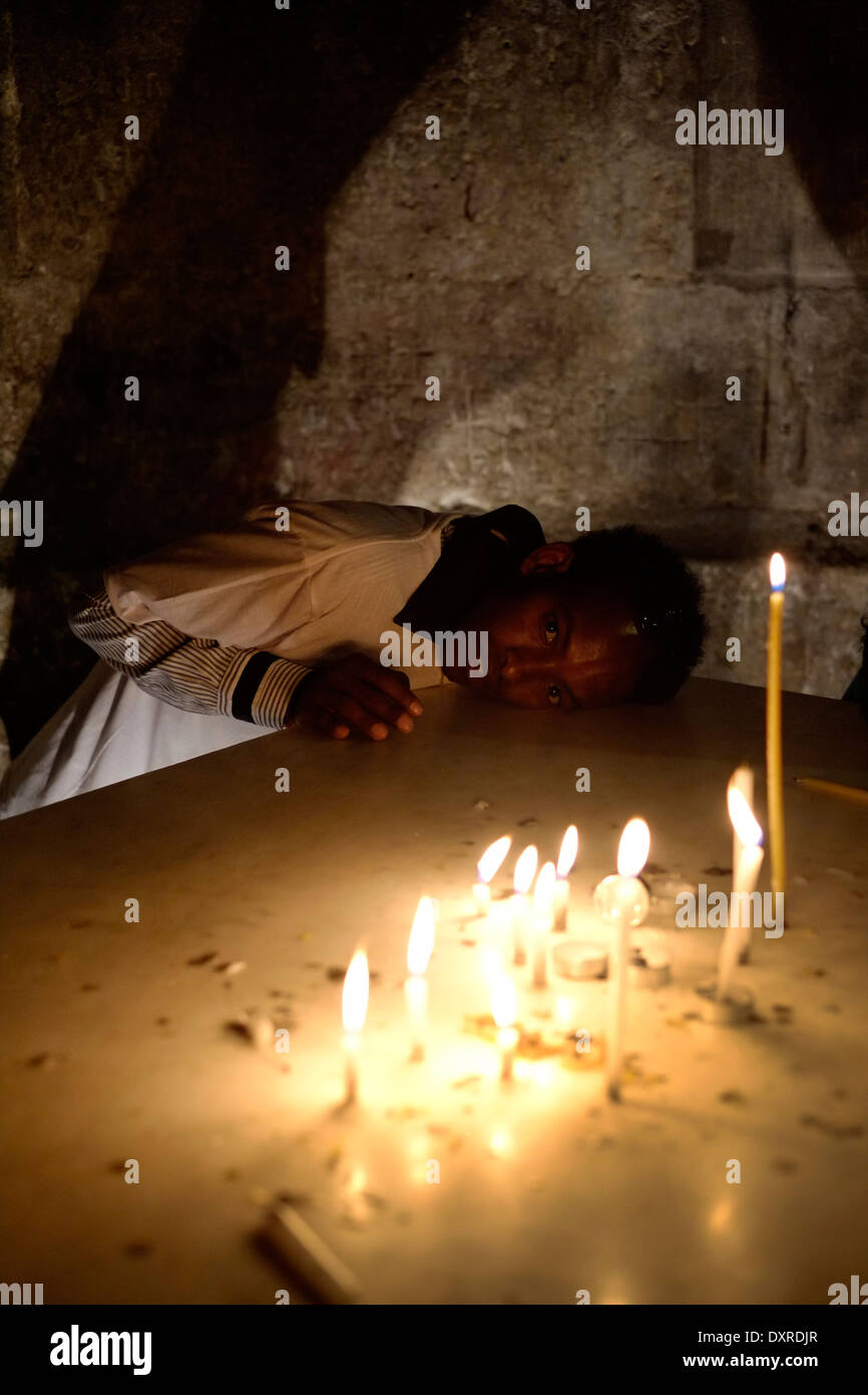 A Christian pilgrim from Eritrea rest his head on the altar of the