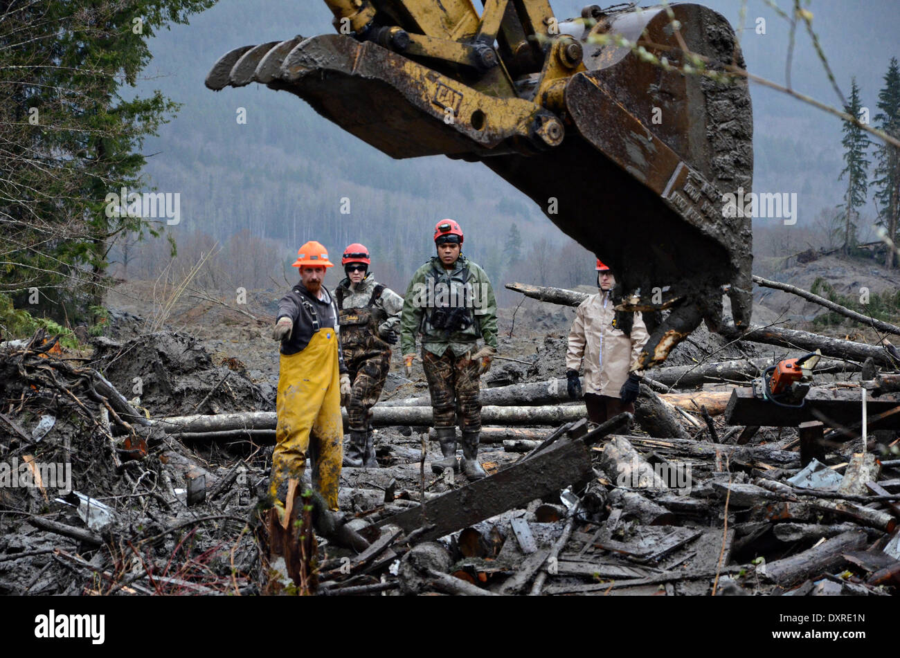 Rescue workers continue efforts to locate victims of a massive landslide that killed at least 28 people and destroyed a small riverside village in northwestern Washington state March 29, 2014 in Oso, Washington. Stock Photo
