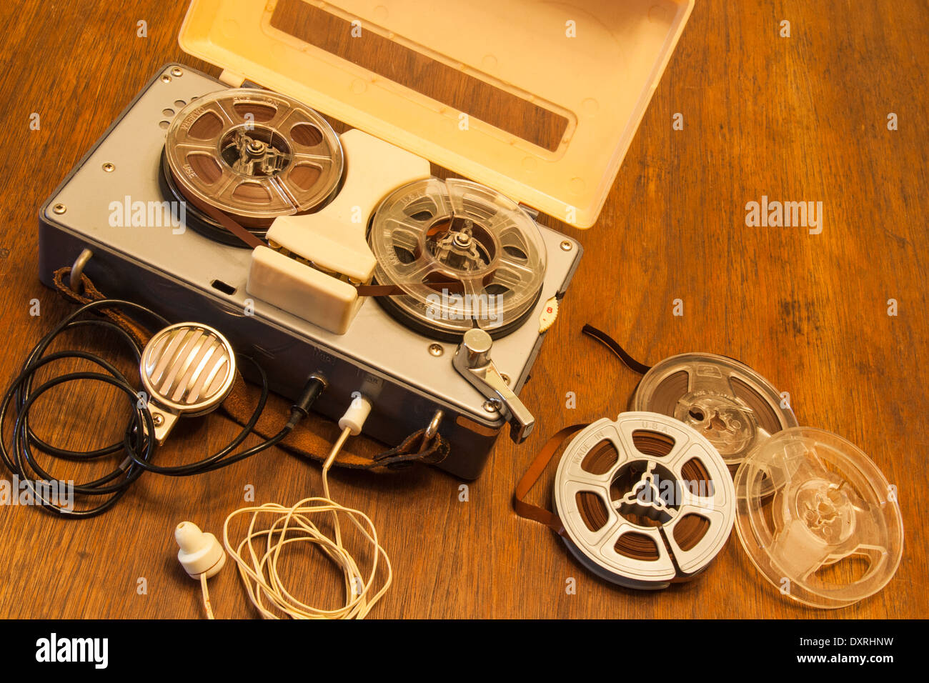 An antique toy tape recorder from the 1950s or 60s with lapel microphone, earphone and reels of magnetic recording tape. Stock Photo