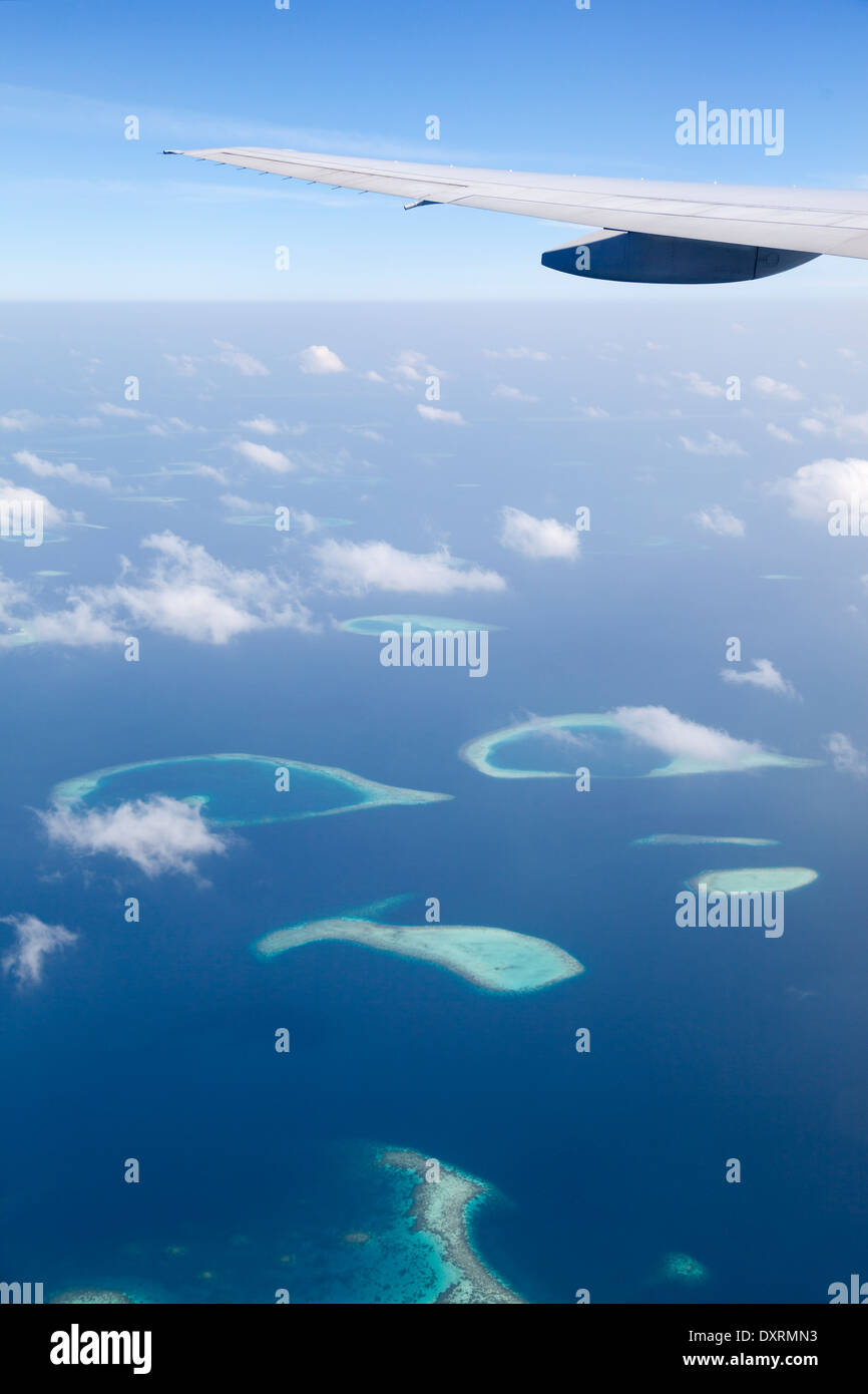 View from the window of an airplane flying above the Maldive Islands in the Indian Ocean Stock Photo
