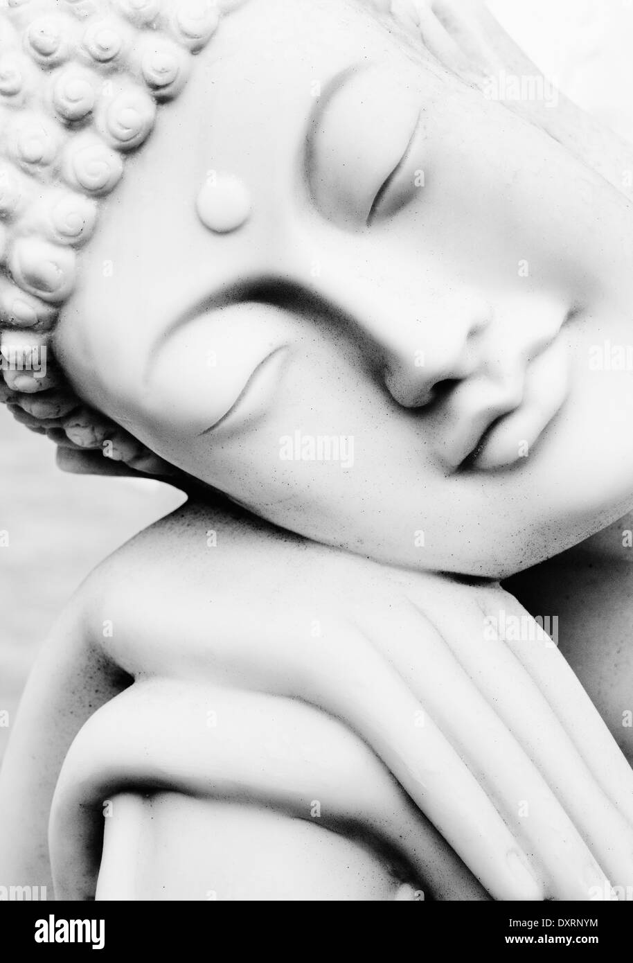 Peaceful white marble Buddha statue. Monochrome Stock Photo