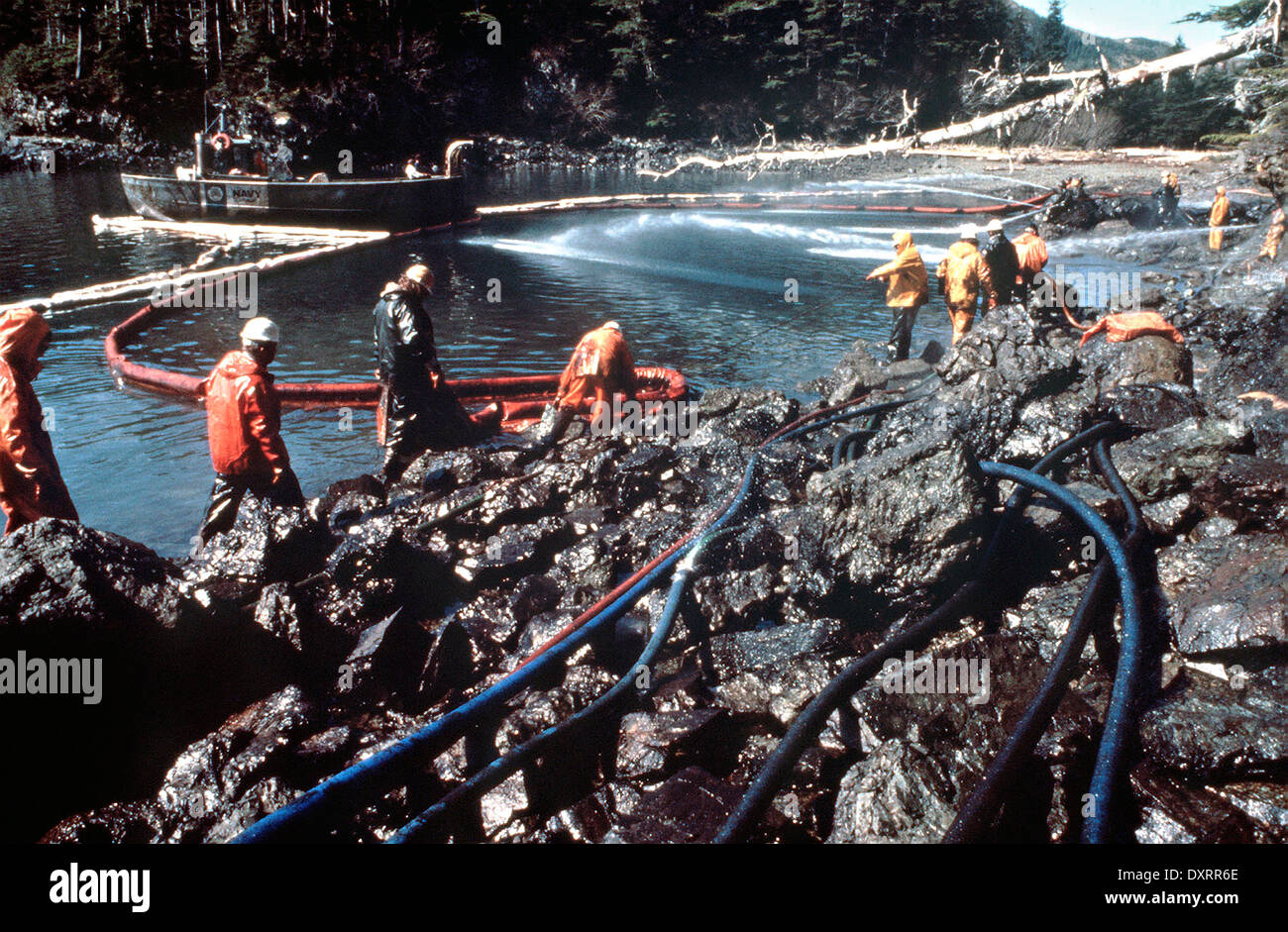 Workers steam blast rocks and wash down the shoreline soaked in crude
