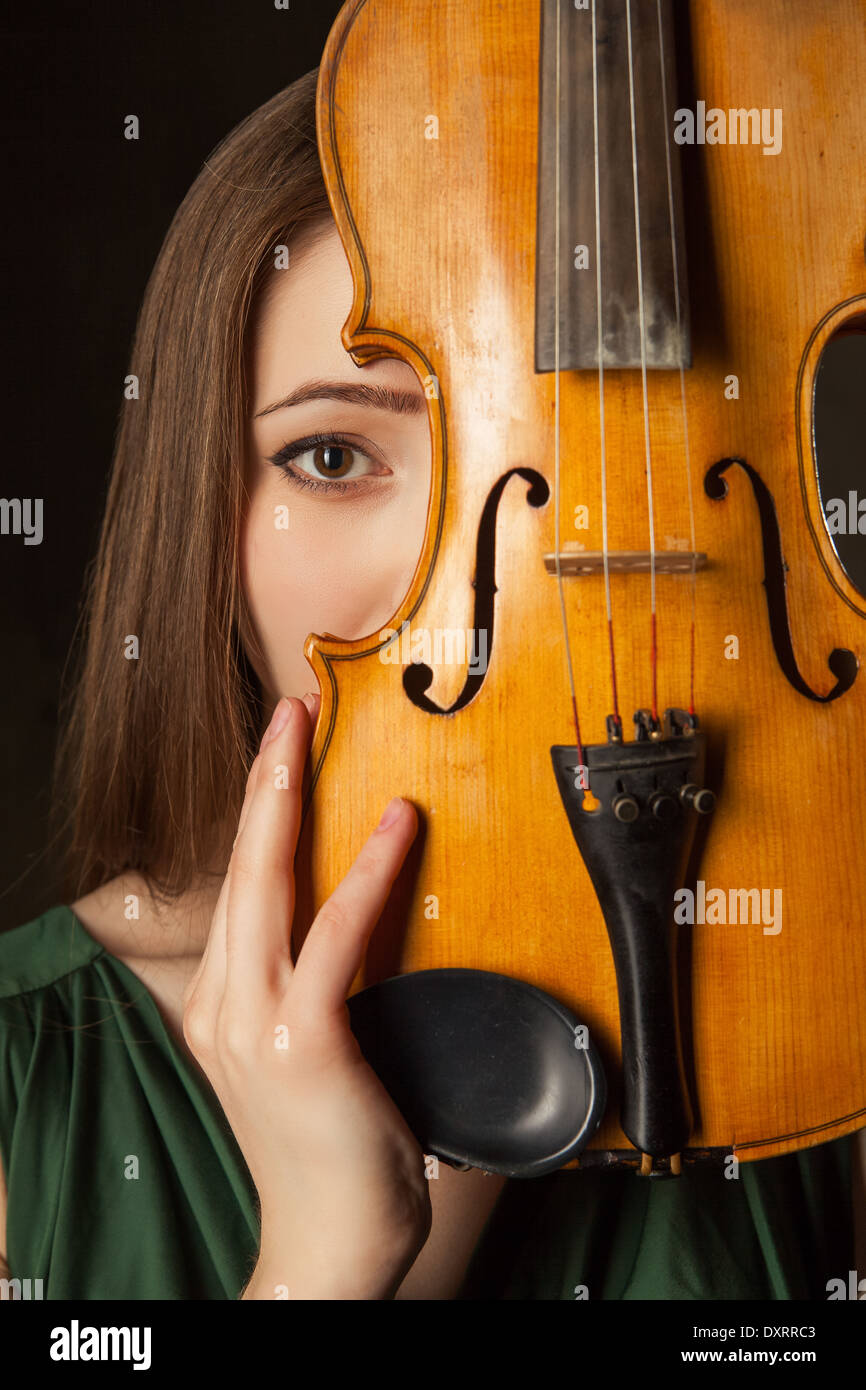 Beautiful young woman playing violin over black background Stock Photo ...
