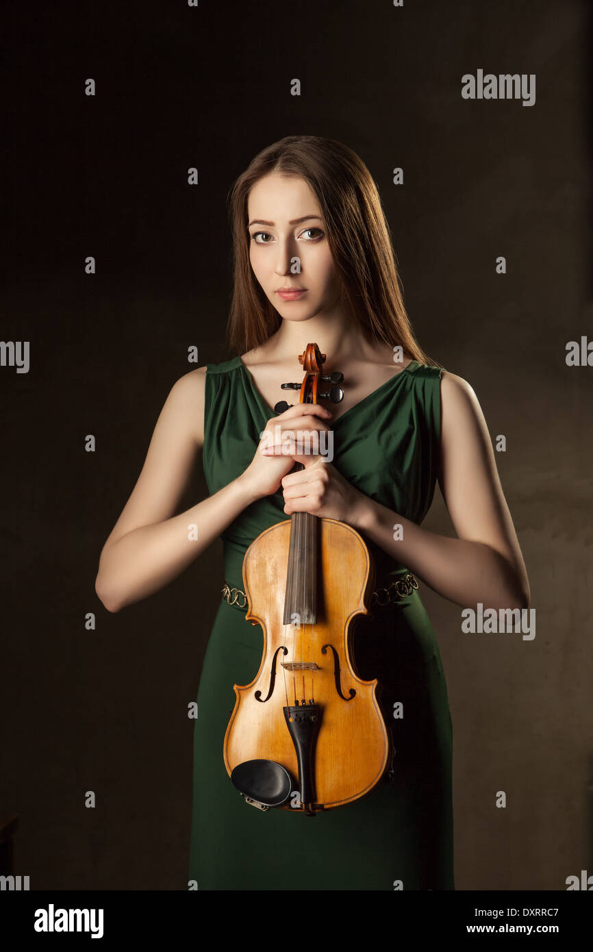Beautiful young woman playing violin over black background Stock Photo ...