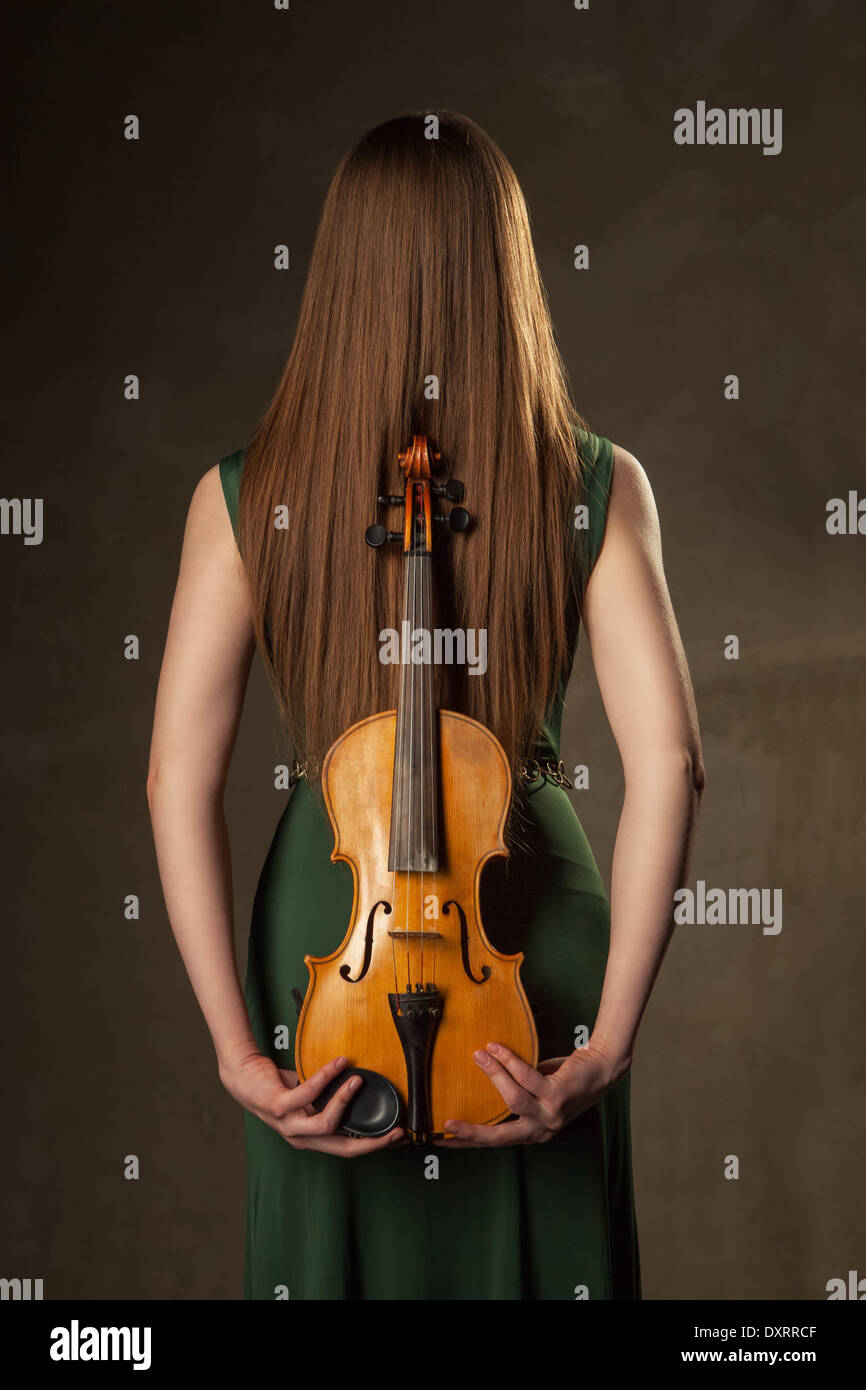 Beautiful young woman playing violin over black background Stock Photo ...
