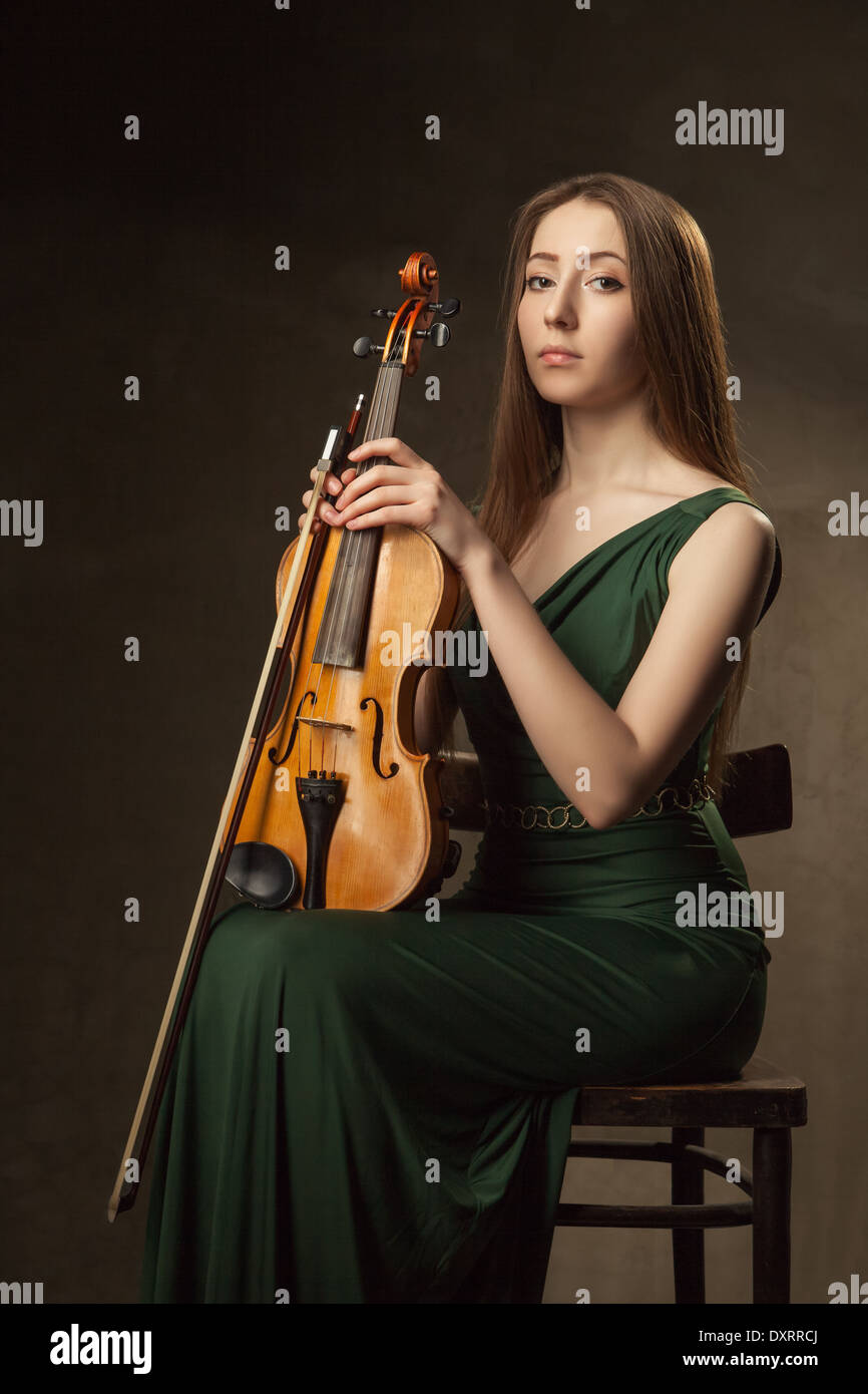 Beautiful young woman playing violin over black background Stock Photo ...