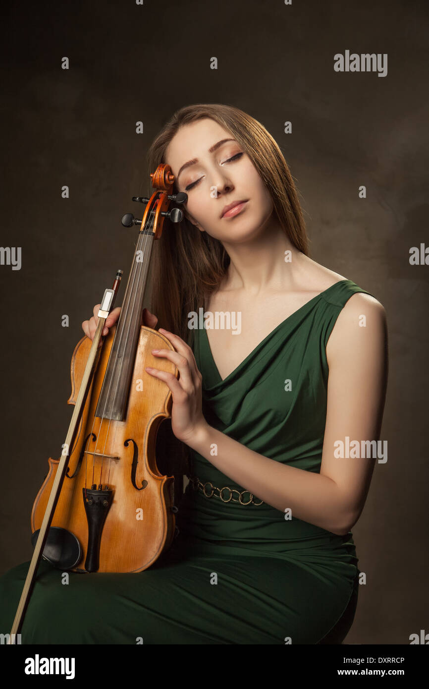 Beautiful young woman playing violin over black background Stock Photo ...