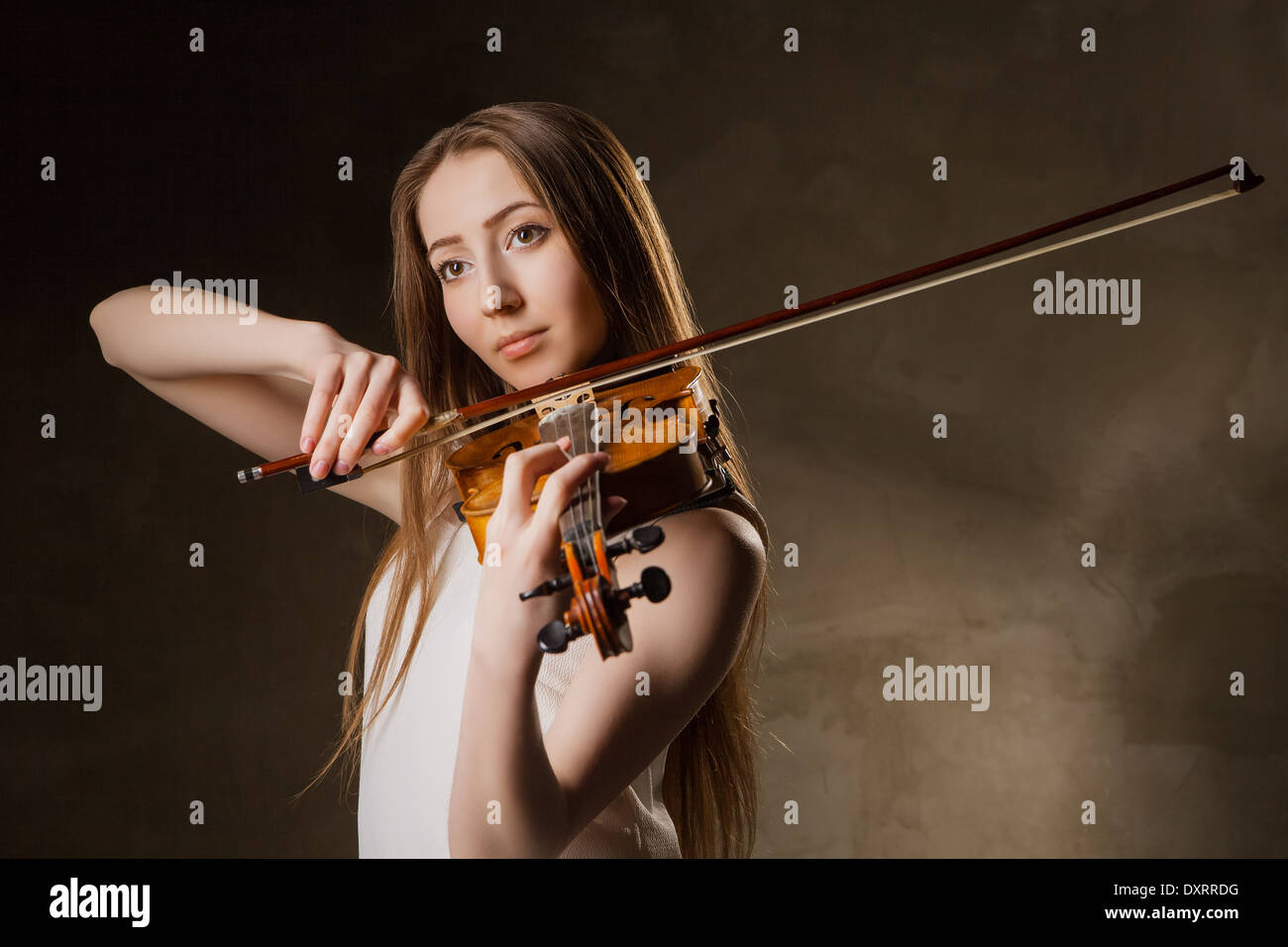 Beautiful young woman playing violin over black background Stock Photo ...