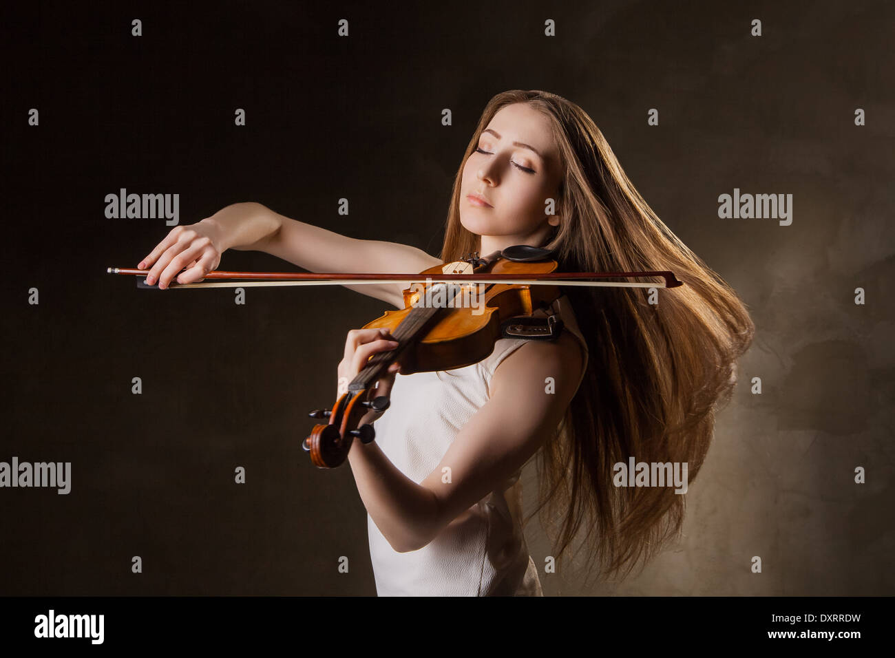 Beautiful young woman playing violin over black background Stock Photo ...