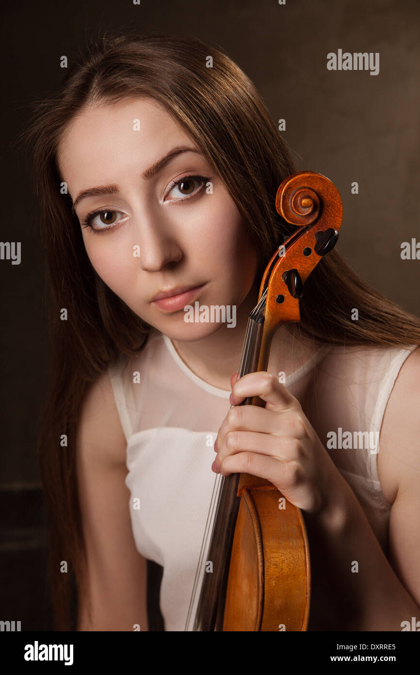 Beautiful young woman playing violin over black background Stock Photo ...