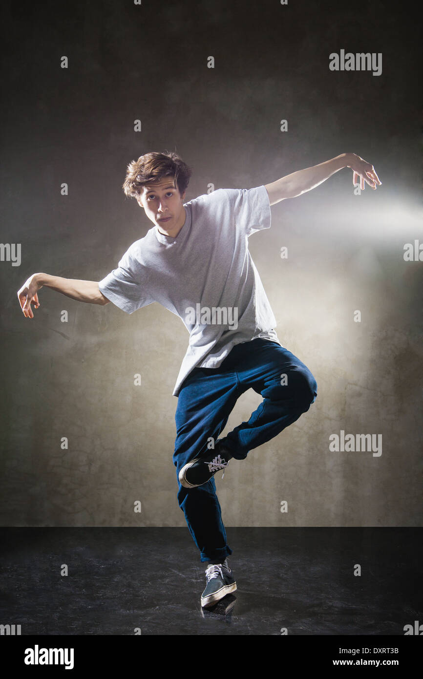 urban hip hop dancer with grunge concrete wall background texture jumping and dancing Stock Photo