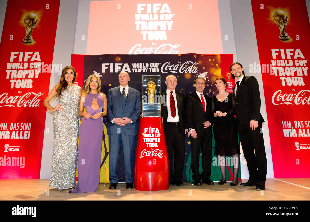 Presenter Jana Ina Zarella (L-R), model Sylvie Meis, former German national soccer players and world champions of 1954 Horst Eckel, Bernd Hoelzenbein of 1974 and Pierre Littbarski of 1990, sports presenter Monica Lierhaus and Borussia Dortmund's player Neven Subotic pose on stage with the original soccer world cup trophy during a gala which took place on the occasion of the FIFA world cup tour in Berlin, Germany, 29 March 2014. The FIFA World CUp trophy is touring across the glob through 90 countries in preparation for the forthcoming soccer world cup in Brazil. Photo: Kay Nietfeld/dpa Stock Photo