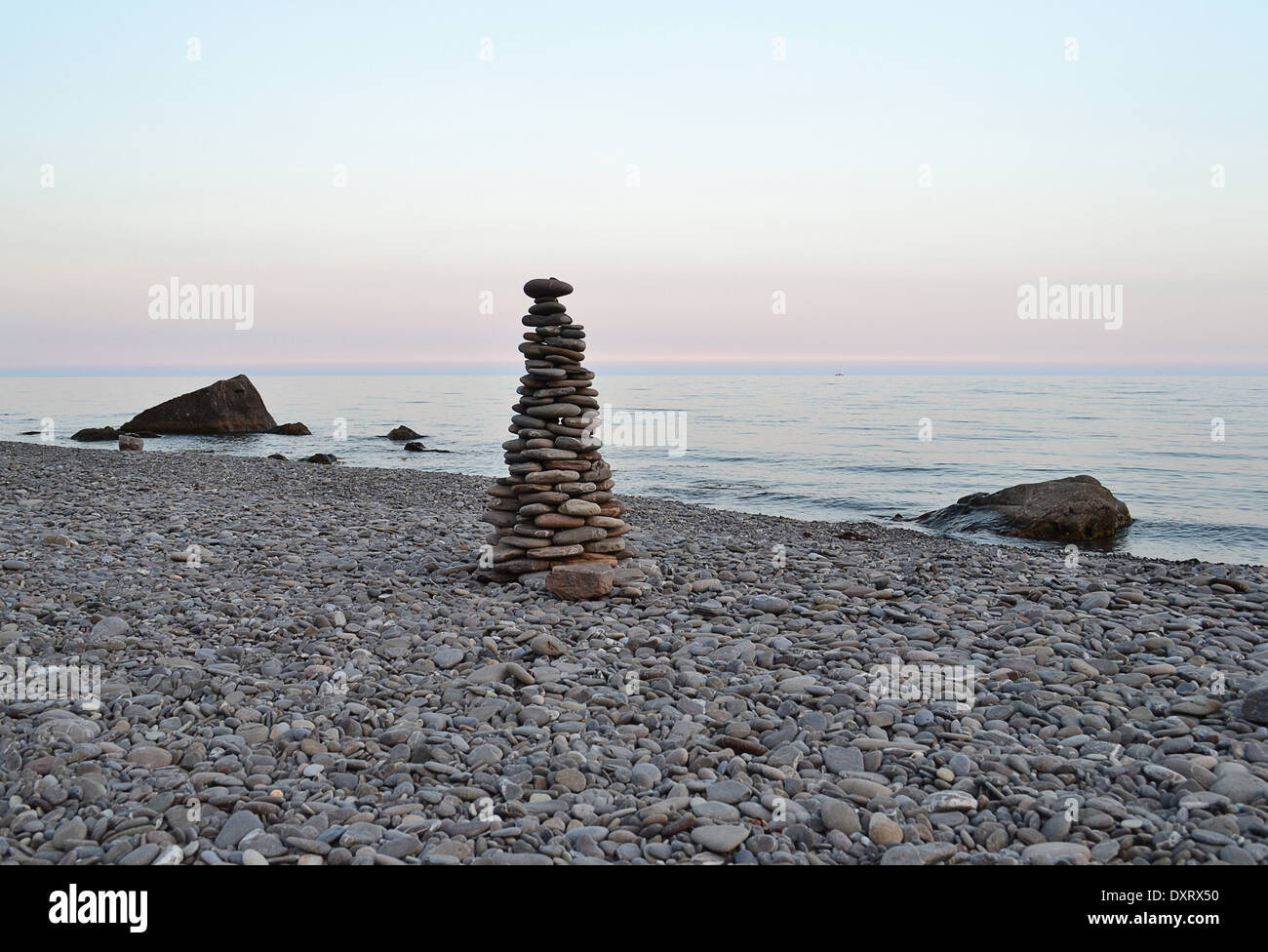 pyramid of stones on the beach during sunset Stock Photo