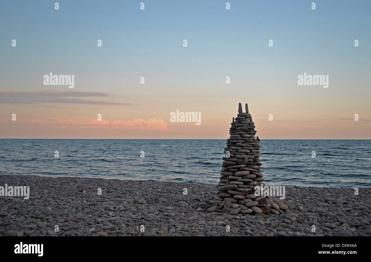 pyramid of stones on the beach during sunset Stock Photo