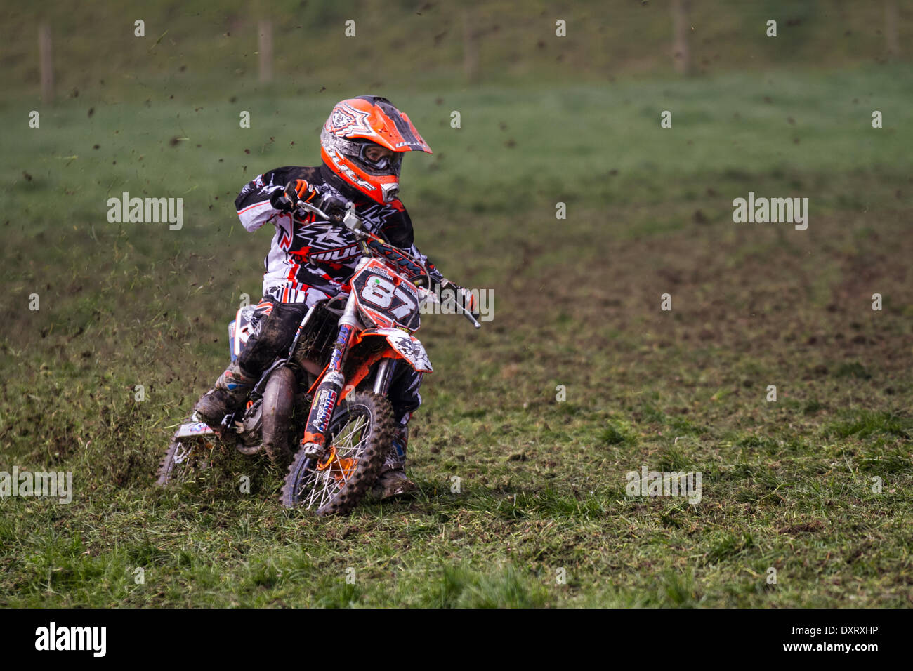 Youngsters grass track motorcycle riding in Much Hoole, Lancashire, UK March, 2014. Mickie Simpson MX65 rider and winner at the first ever meeting of the Lancashire Offroad Grasstrack Association held at Lower Marsh Farm, Much Hoole, Preston. A junior motorcycle race, grass track, speed, bike, motorbike, motorsport, power, winner, racing, motocross, competition, extreme sports, helmet, wheel, moto, sport, rider, cross, fun, jump, riding, sports, trail, dirt, fast event held under the National Sporting Code rules of the ACU standing regulations for grass tracks. Stock Photo
