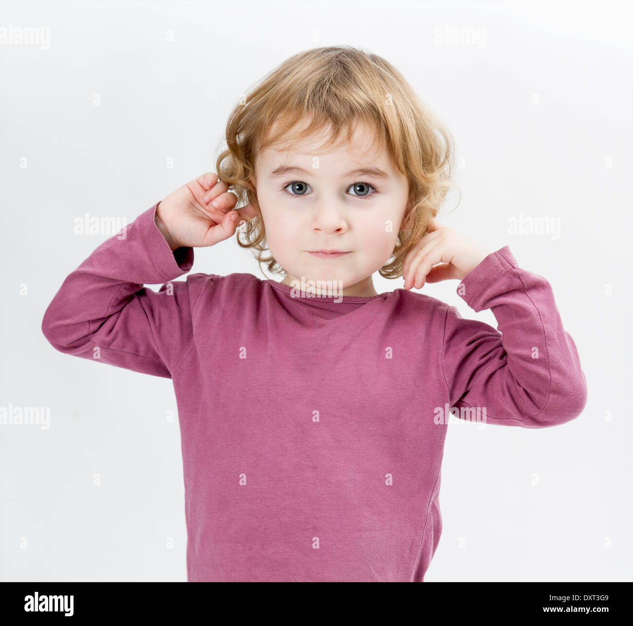 young child with finger in ears isolated on white background Stock Photo