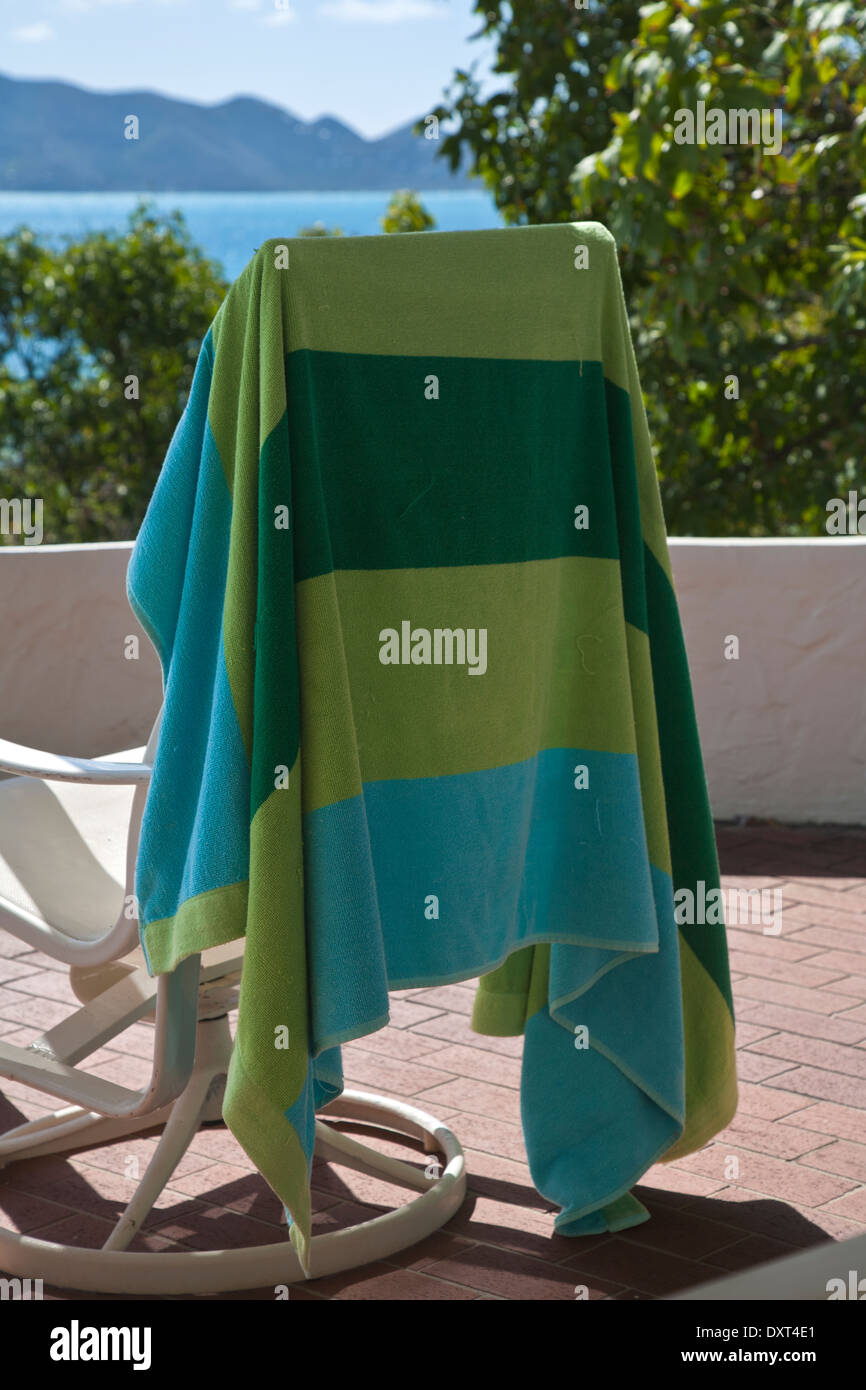 blue and green striped towel draped across back of deck chair echoes