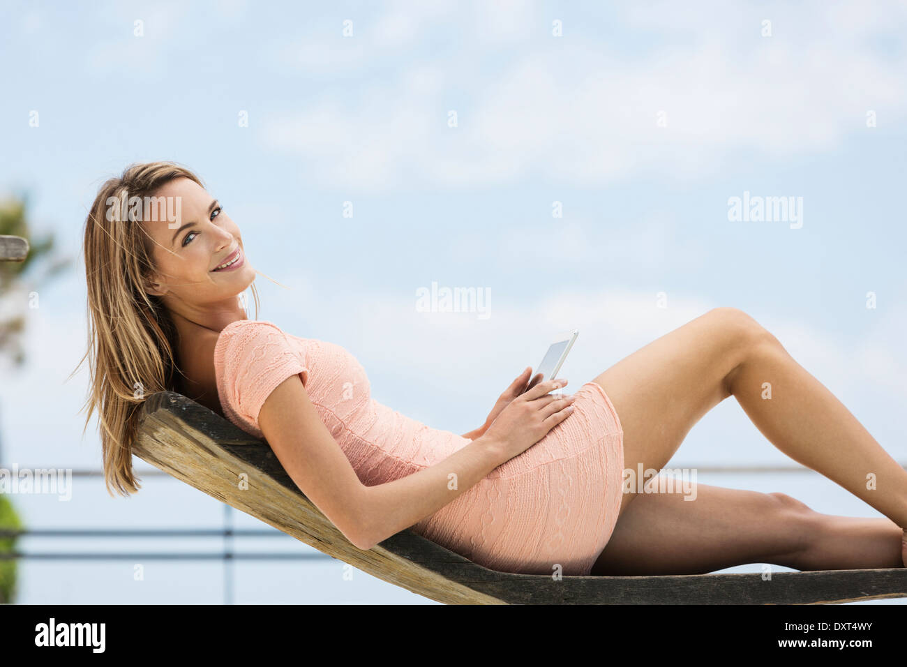 Portrait of smiling woman using digital tablet on lounge chair Stock Photo