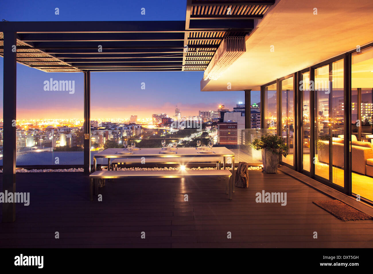 Illuminated luxury house and patio overlooking city Stock Photo