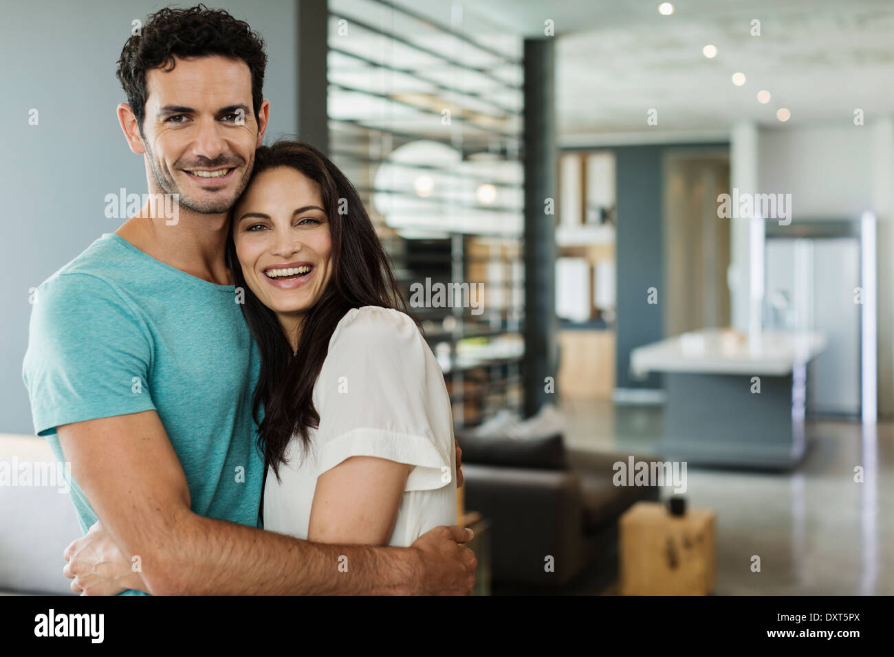 Portrait of happy couple hugging at home Stock Photo