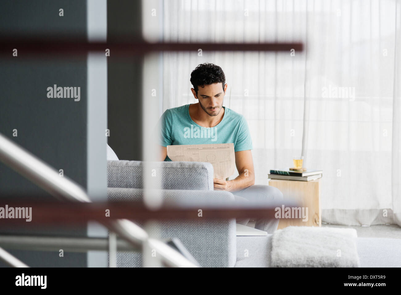 Man reading newspaper in livingroom Stock Photo