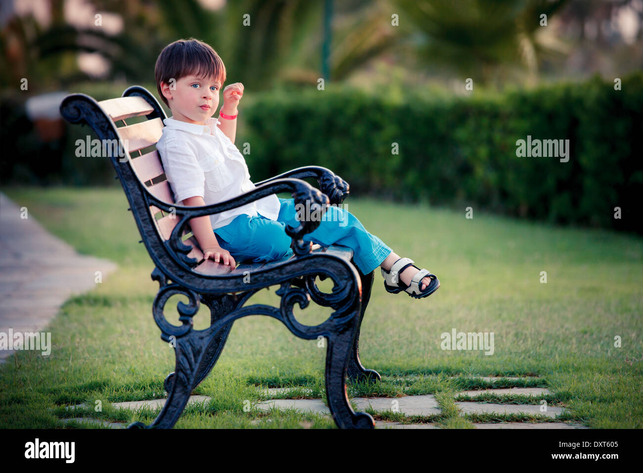 Three years old boy sitting on bench in park Stock Photo - Alamy