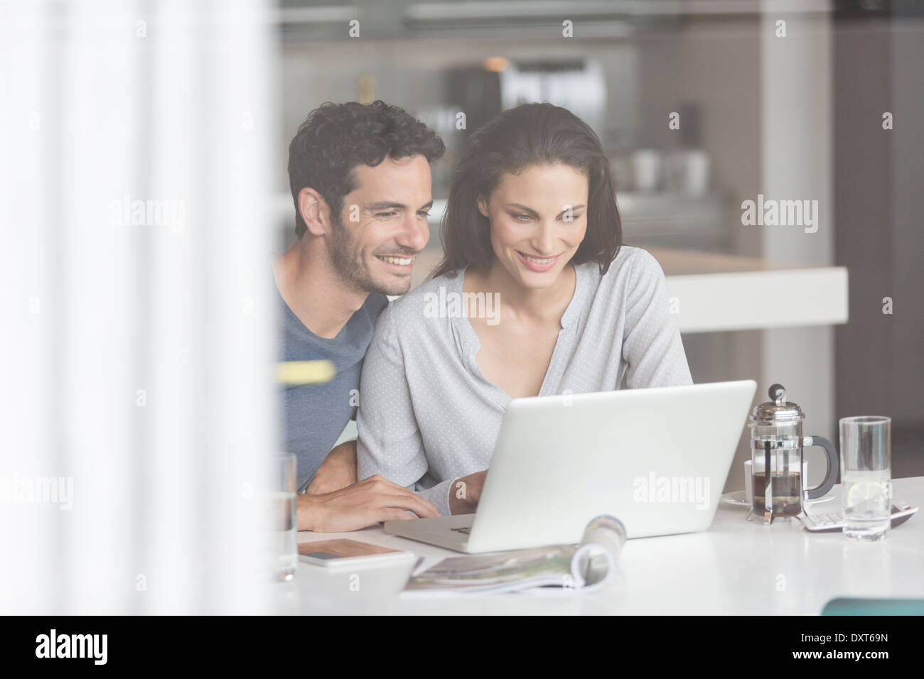 Couple using laptop at table Stock Photo