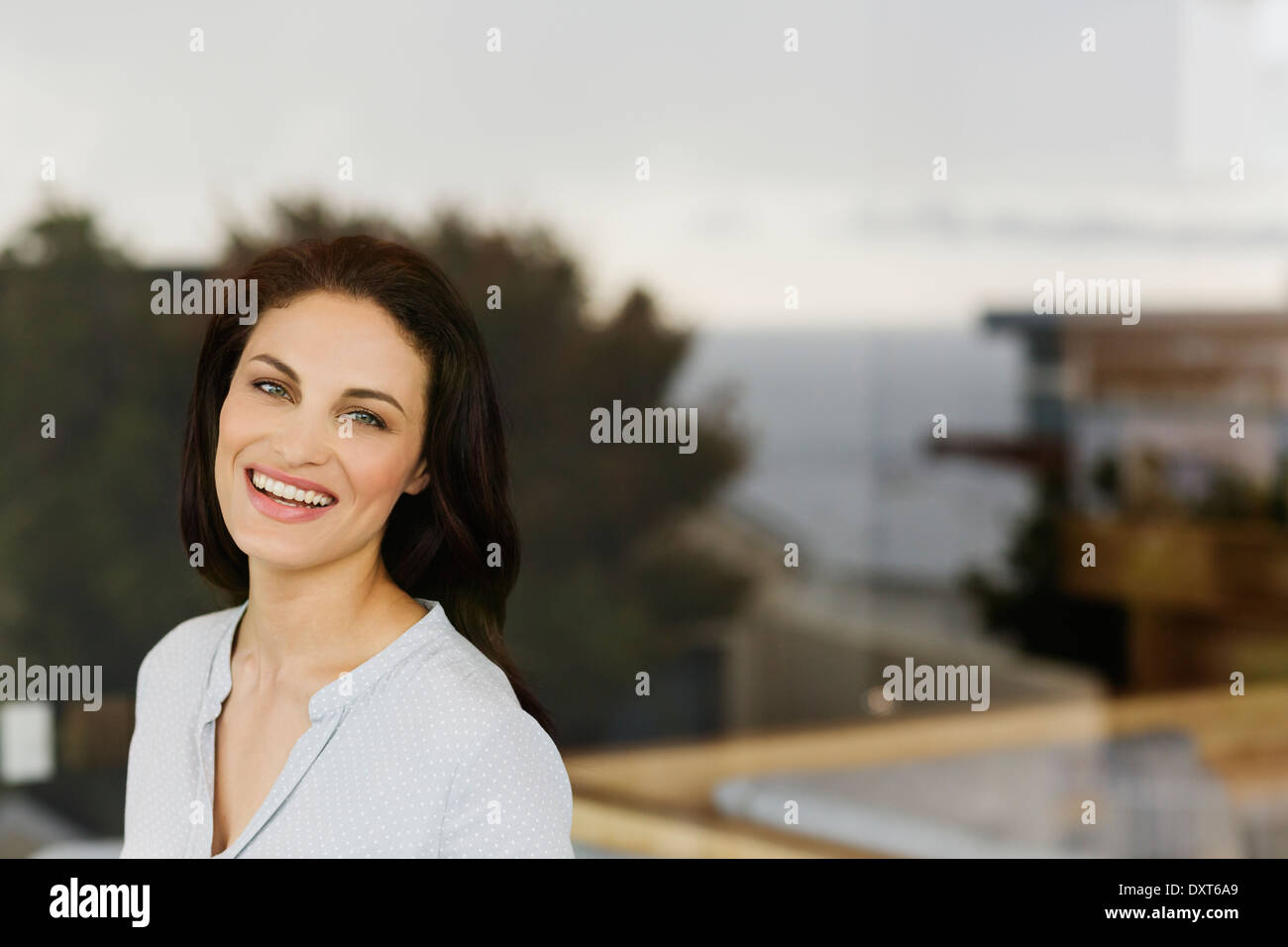 Portrait of woman laughing at window Stock Photo
