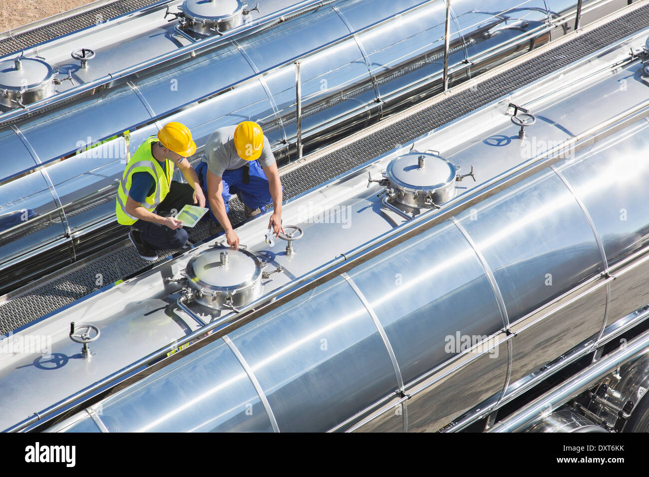 Workers on platform above stainless steel milk tanker Stock Photo