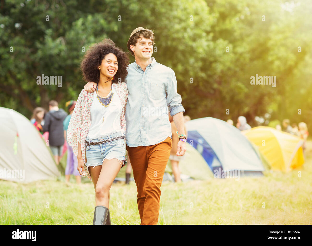Couple walking outside tents at music festival Stock Photo