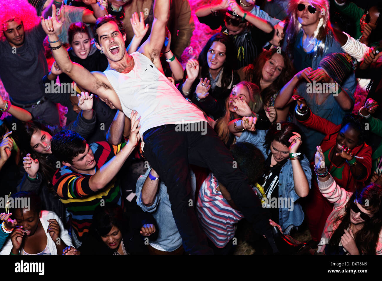 Man crowd surfing at music festival Stock Photo