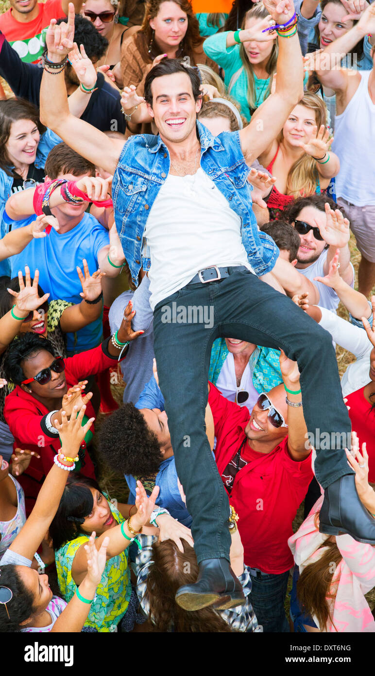 Portrait of man crowd surfing at music festival Stock Photo