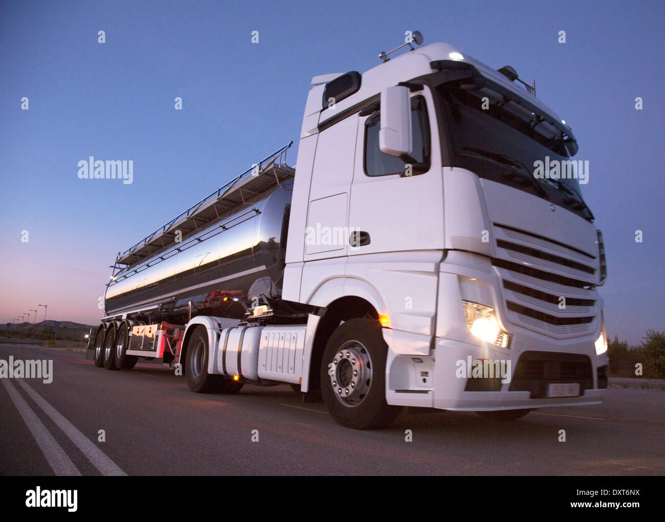 Stainless steel milk tanker on the road at night Stock Photo