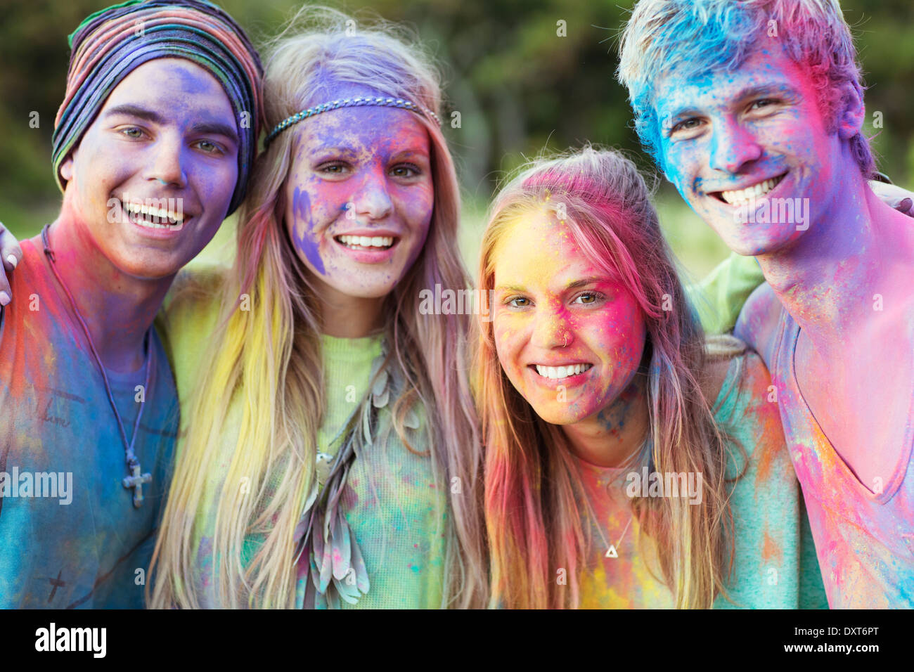 Close up portrait of friends covered in chalk dye at music festival Stock Photo
