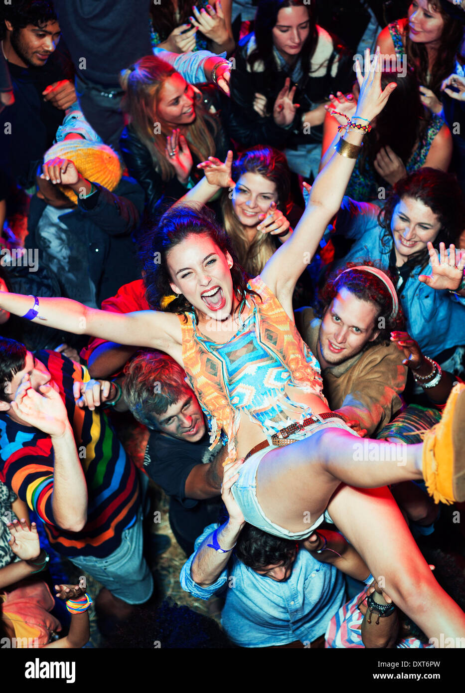 Enthusiastic woman crowd surfing at music festival Stock Photo