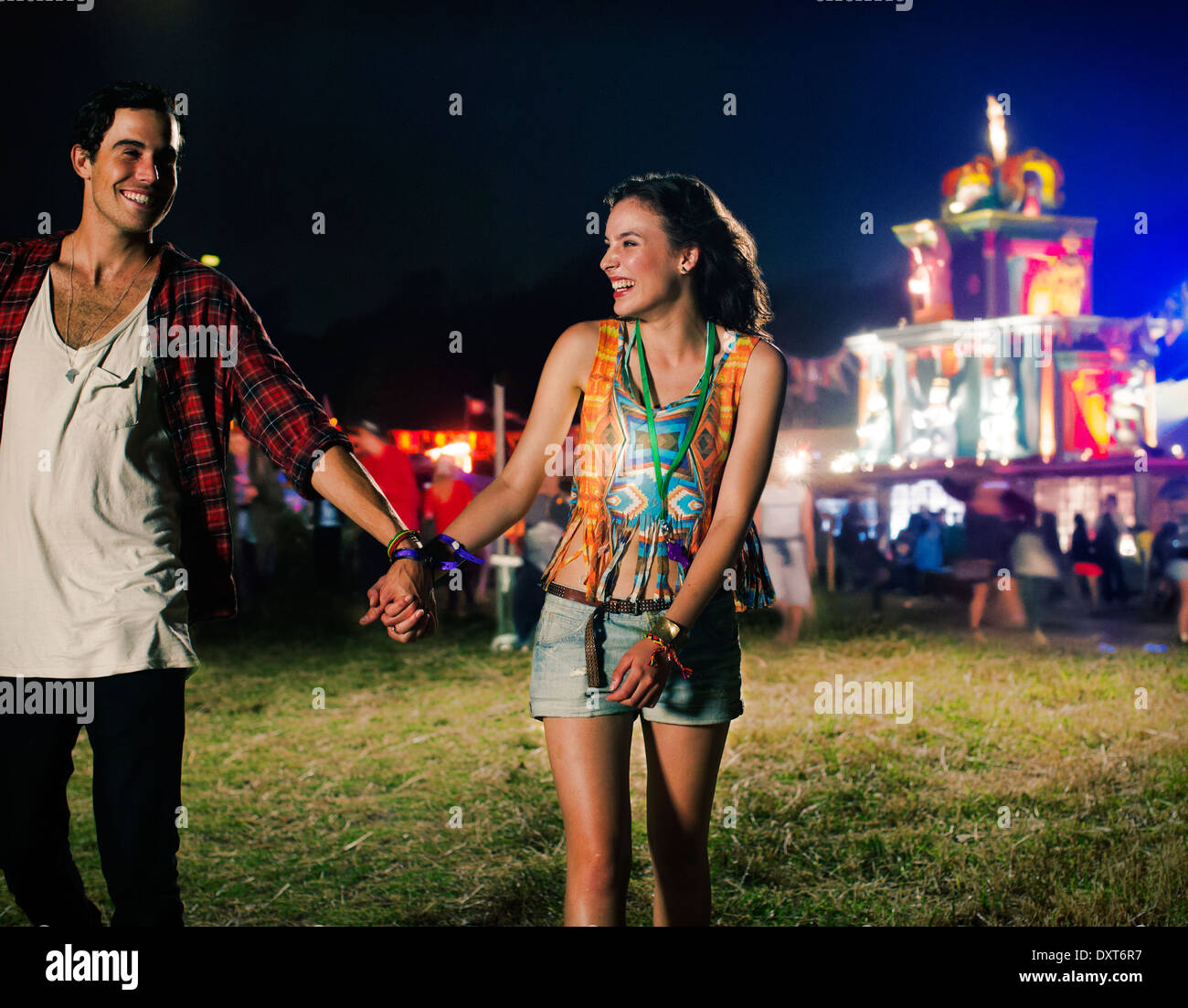 Couple holding hands and leaving music festival Stock Photo