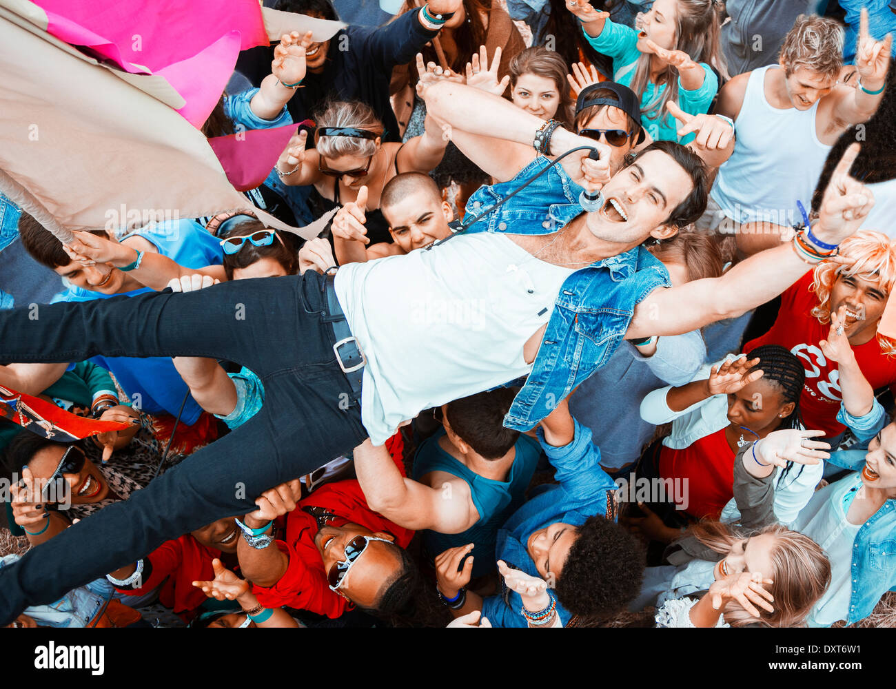 Performer singing and crowd surfing at music festival Stock Photo