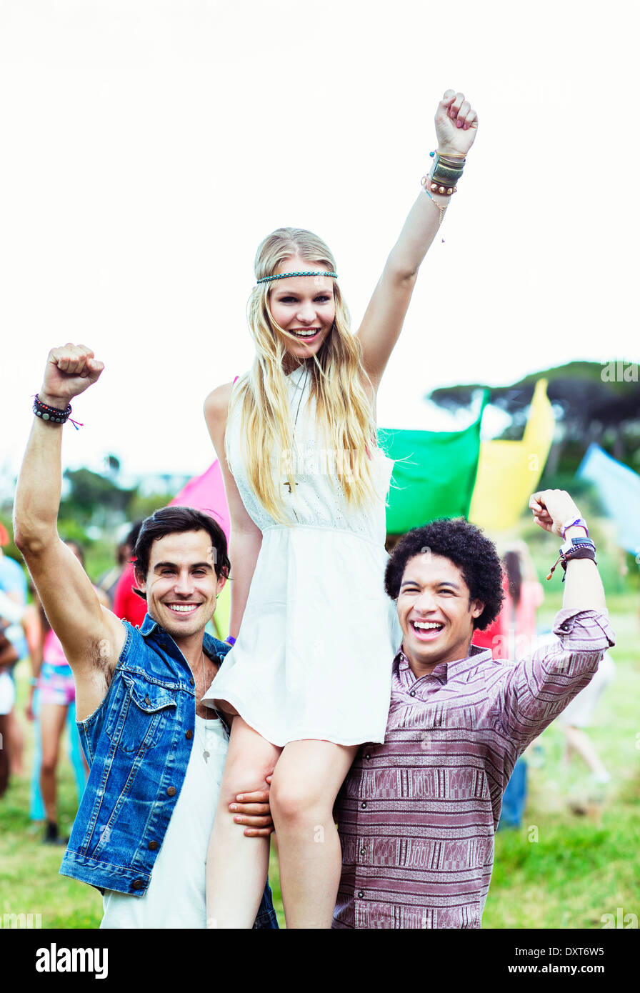 Portrait of men carrying woman at music festival Stock Photo