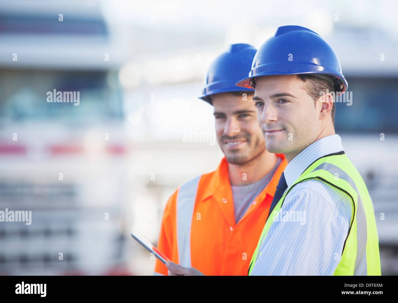 Businessman and worker using digital tablet near trucks Stock Photo