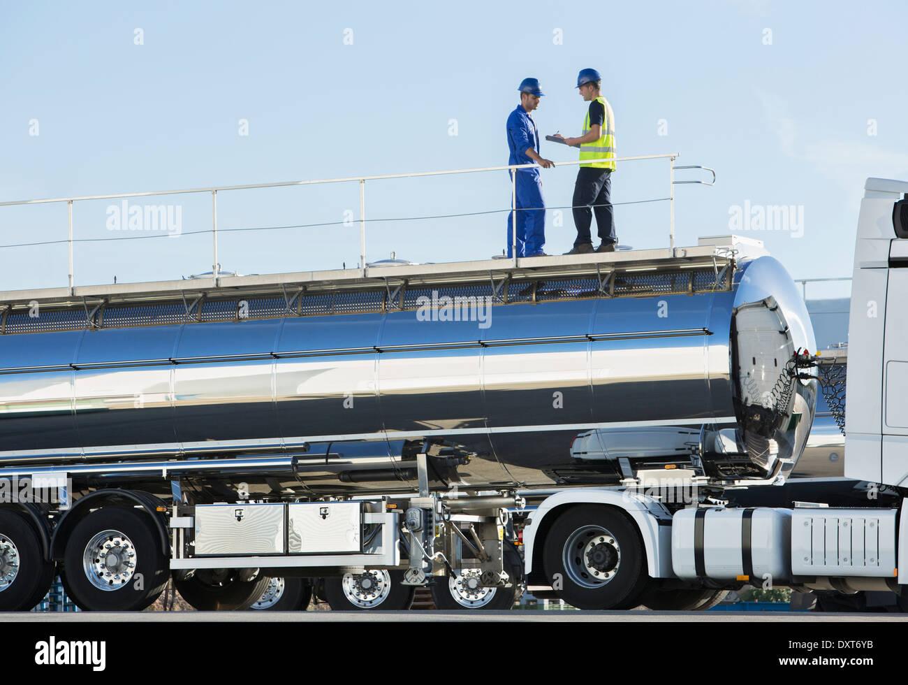 Workers on platform above stainless steel milk tanker Stock Photo Alamy