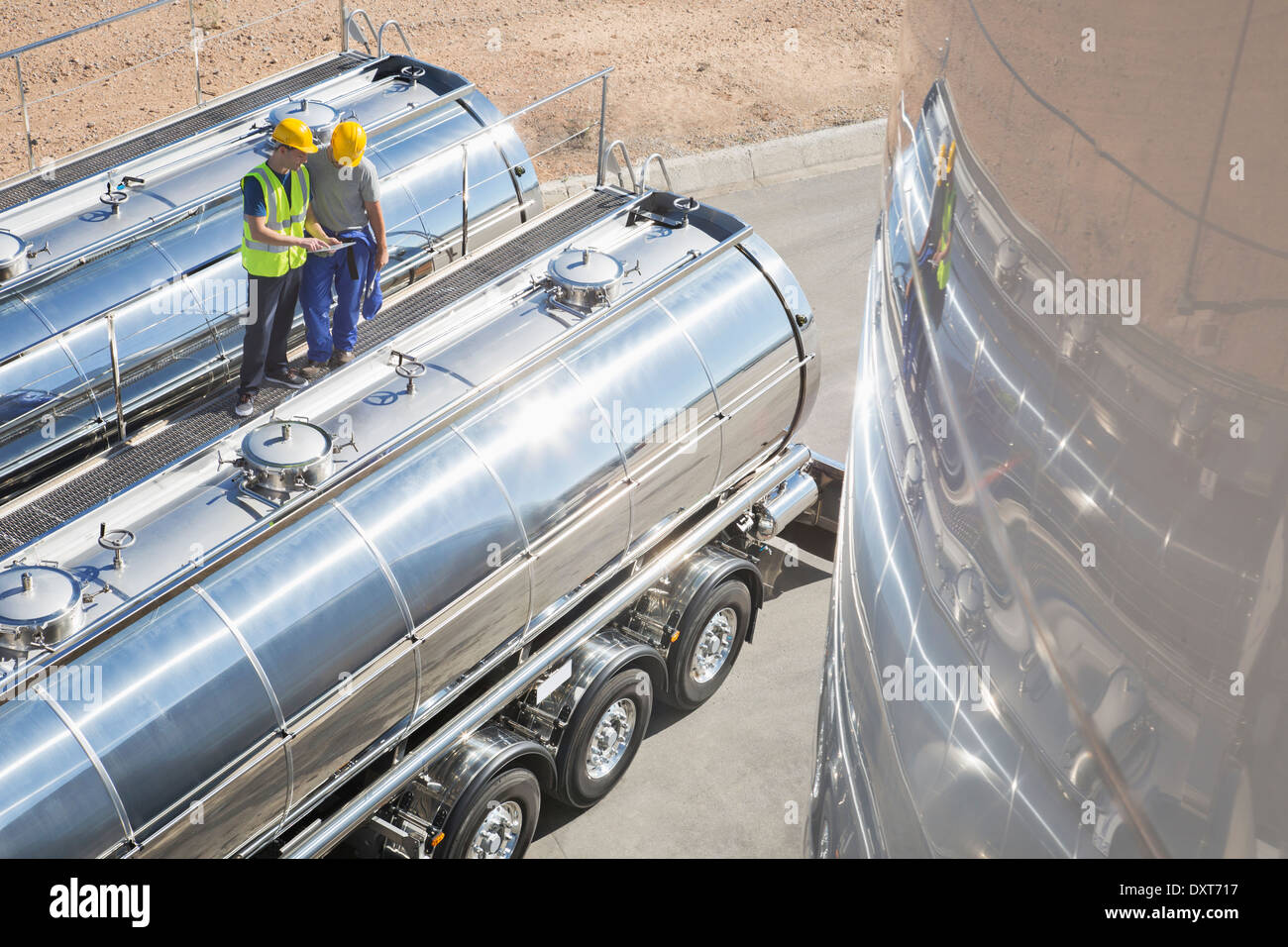Workers on platform above stainless steel milk tanker Stock Photo Alamy