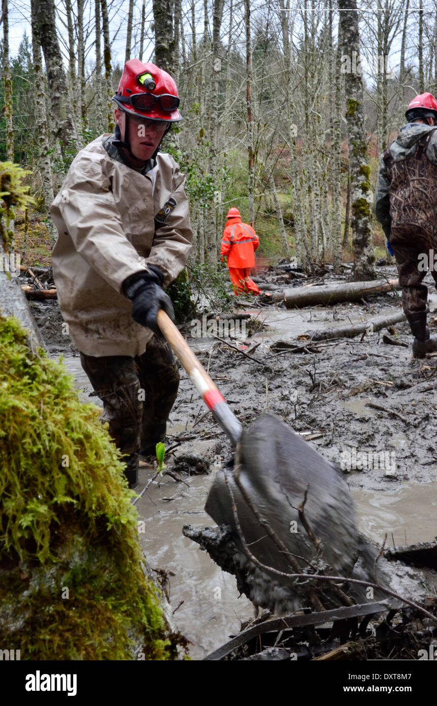 Rescue workers continue efforts to locate victims of a massive landslide that killed at least 28 people and destroyed a small riverside village in northwestern Washington state March 30, 2014 in Oso, Washington. Stock Photo
