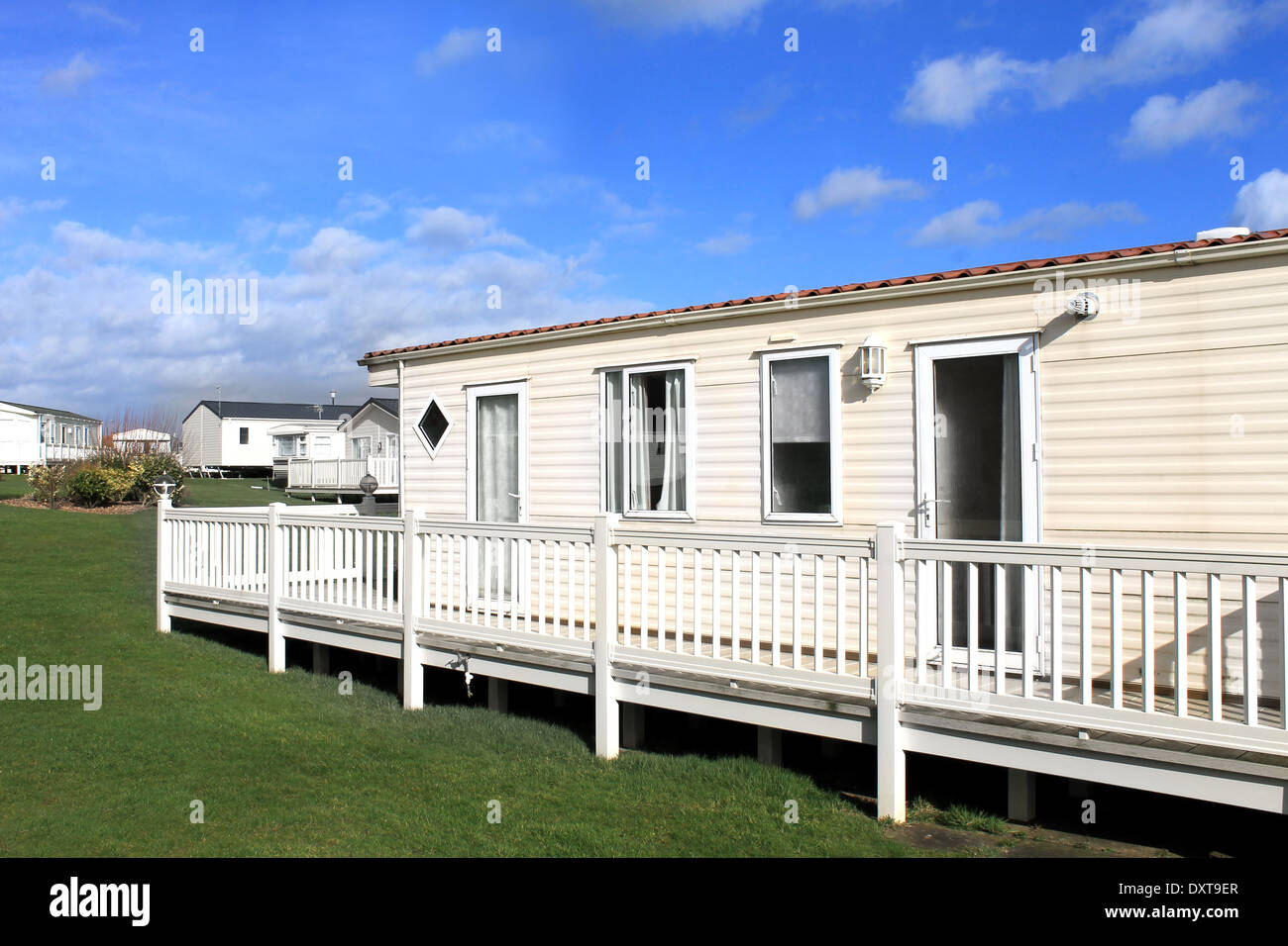 Side view of modern caravan on trailer park with cloudscape background. Stock Photo