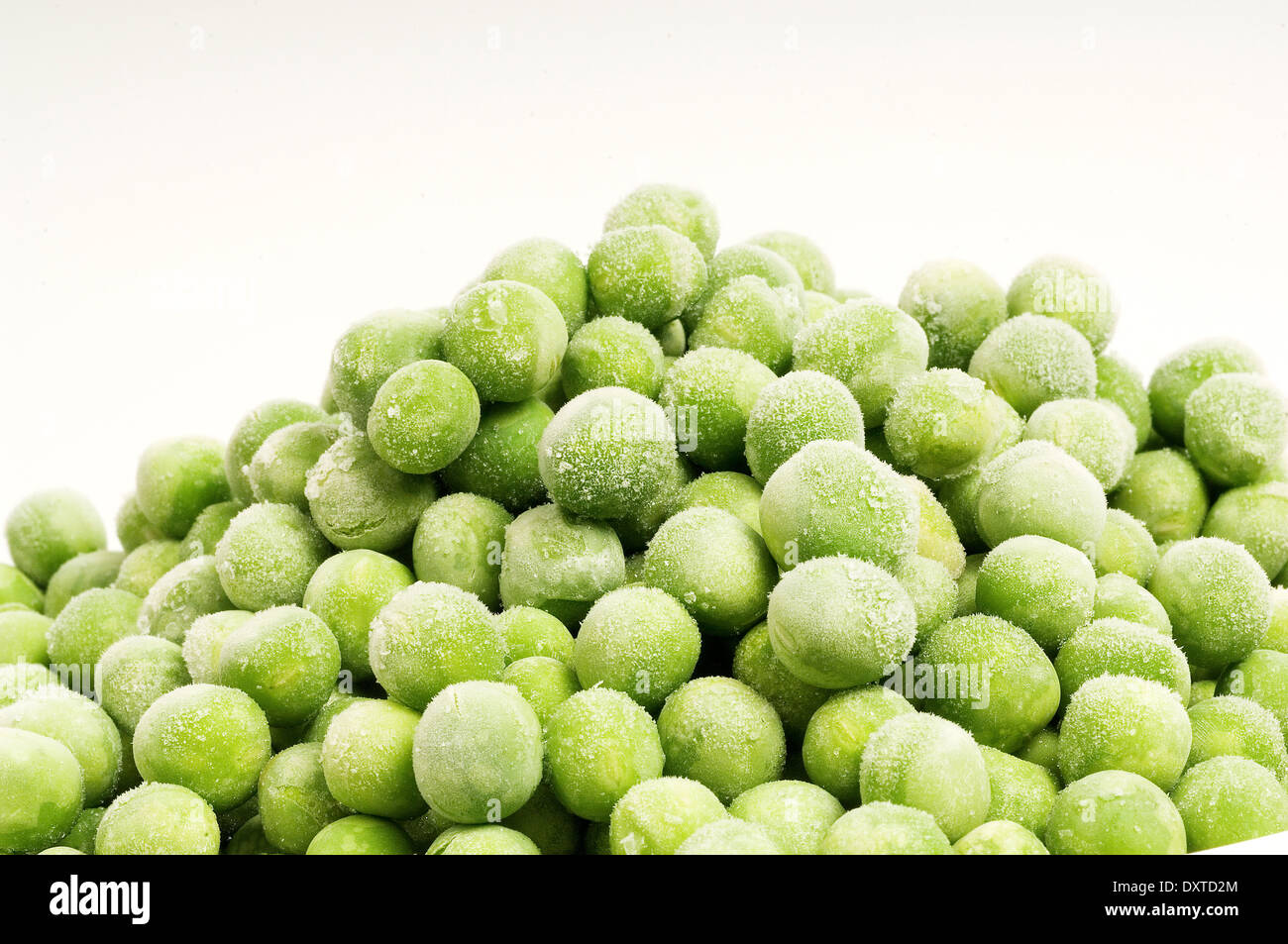 Mound of Frozen Peas against white background Stock Photo